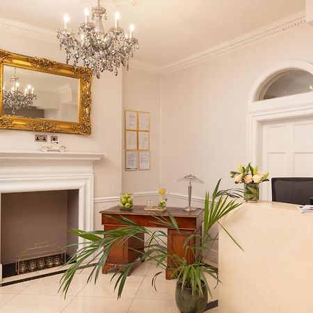 Hotel Montcalm Brewery Townhouse Londres Exterior foto The photo shows a stylish reception area. There is a decorative chandelier hanging from the ceiling, providing elegant lighting. A large, ornate mirror is mounted on the wall beside the fireplace, which features a simple, classic design. In front of 