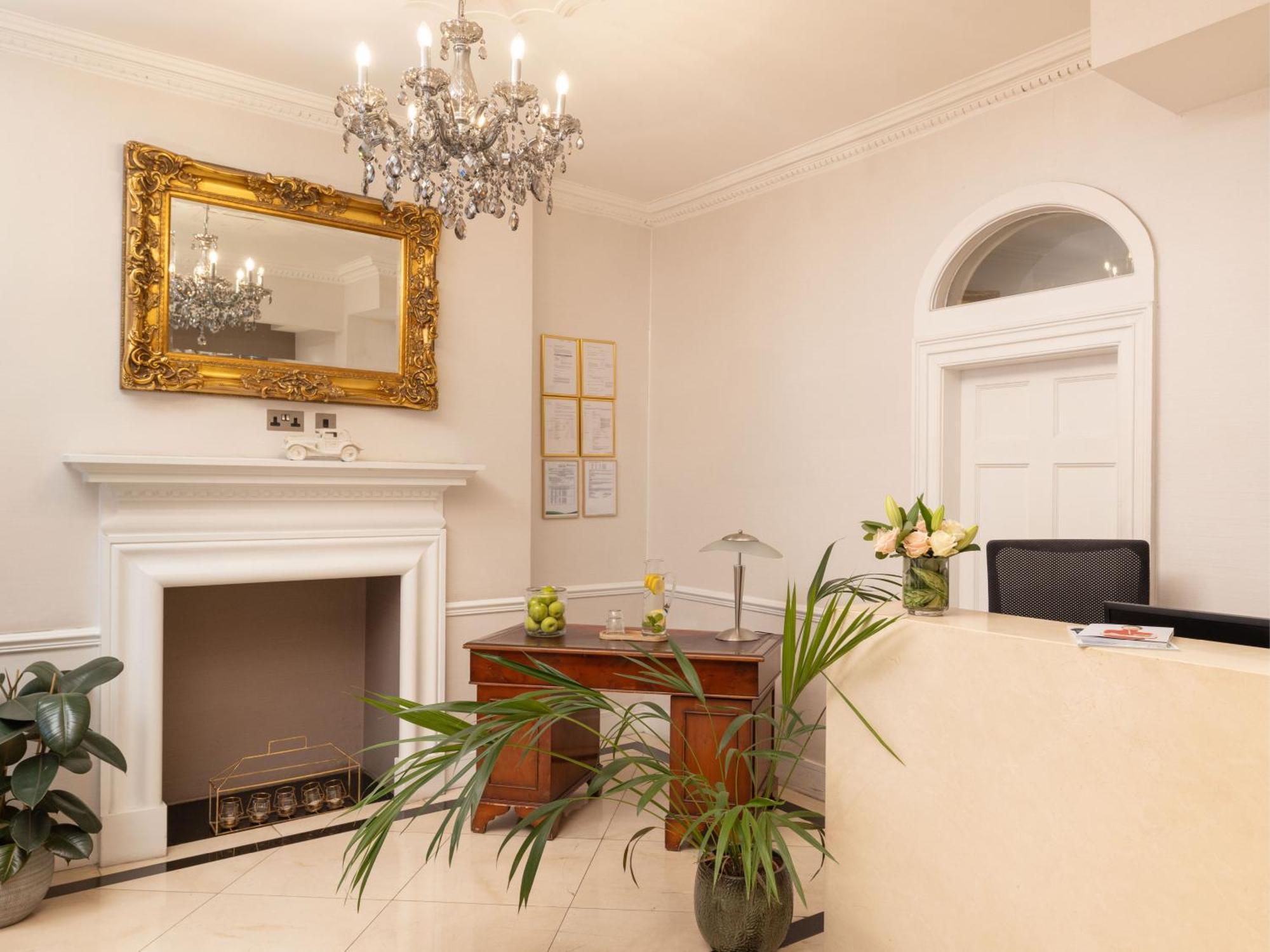 Hotel Montcalm Brewery Townhouse Londres Exterior foto The photo shows a stylish reception area. There is a decorative chandelier hanging from the ceiling, providing elegant lighting. A large, ornate mirror is mounted on the wall beside the fireplace, which features a simple, classic design. In front of 