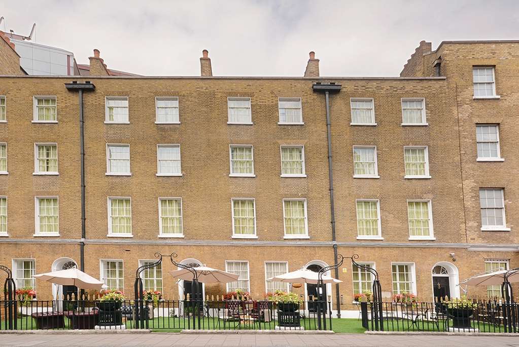 Hotel Montcalm Brewery Townhouse Londres Exterior foto The photo shows a brick building with several windows on its facade. The structure appears to be three stories tall, featuring a symmetrical design with multiple windows that have white frames. In front of the building, there is a landscaped area wit