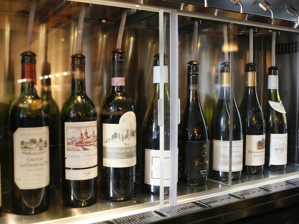 Hotel Montcalm Brewery Townhouse Londres Exterior foto The photo depicts a selection of wine bottles displayed in a wine fridge or cooler. The bottles are lined up behind a glass panel, showcasing various types of wine, likely including both red and white varieties. Each bottle has a distinctive label, i