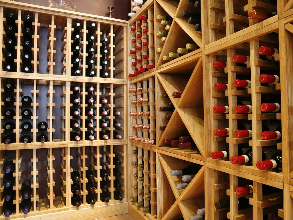Hotel Montcalm Brewery Townhouse Londres Exterior foto The photo shows a wine cellar with wooden racks designed for storing wine bottles. The structure is divided into sections, featuring various compartments that hold the bottles in an organized manner. The bottles have different colors, with many red a